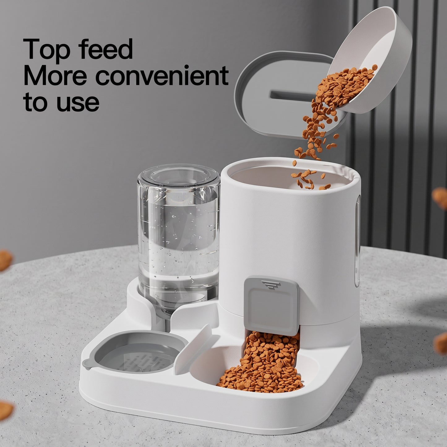 A white automatic pet feeder and water dispenser set on a light gray countertop. Kibble is shown being poured into the feeder from an open lid above, and water is visible in the glass reservoir.