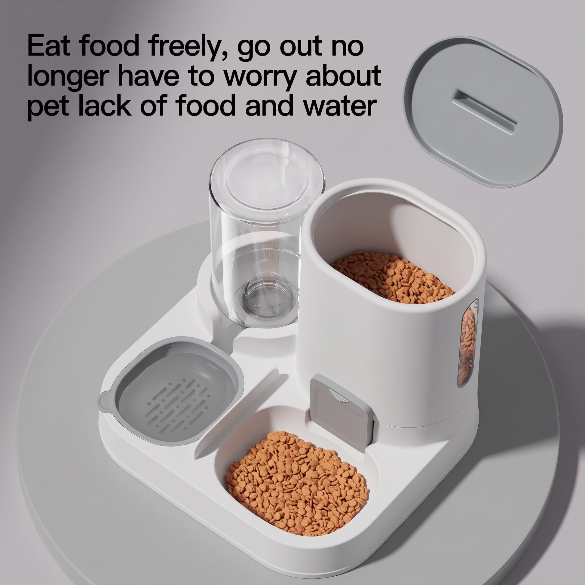 A pet feeder and water dispenser set shown on a light gray surface with food and water containers filled with kibble. The main product is white with gray accents, and a separate lid is shown above.