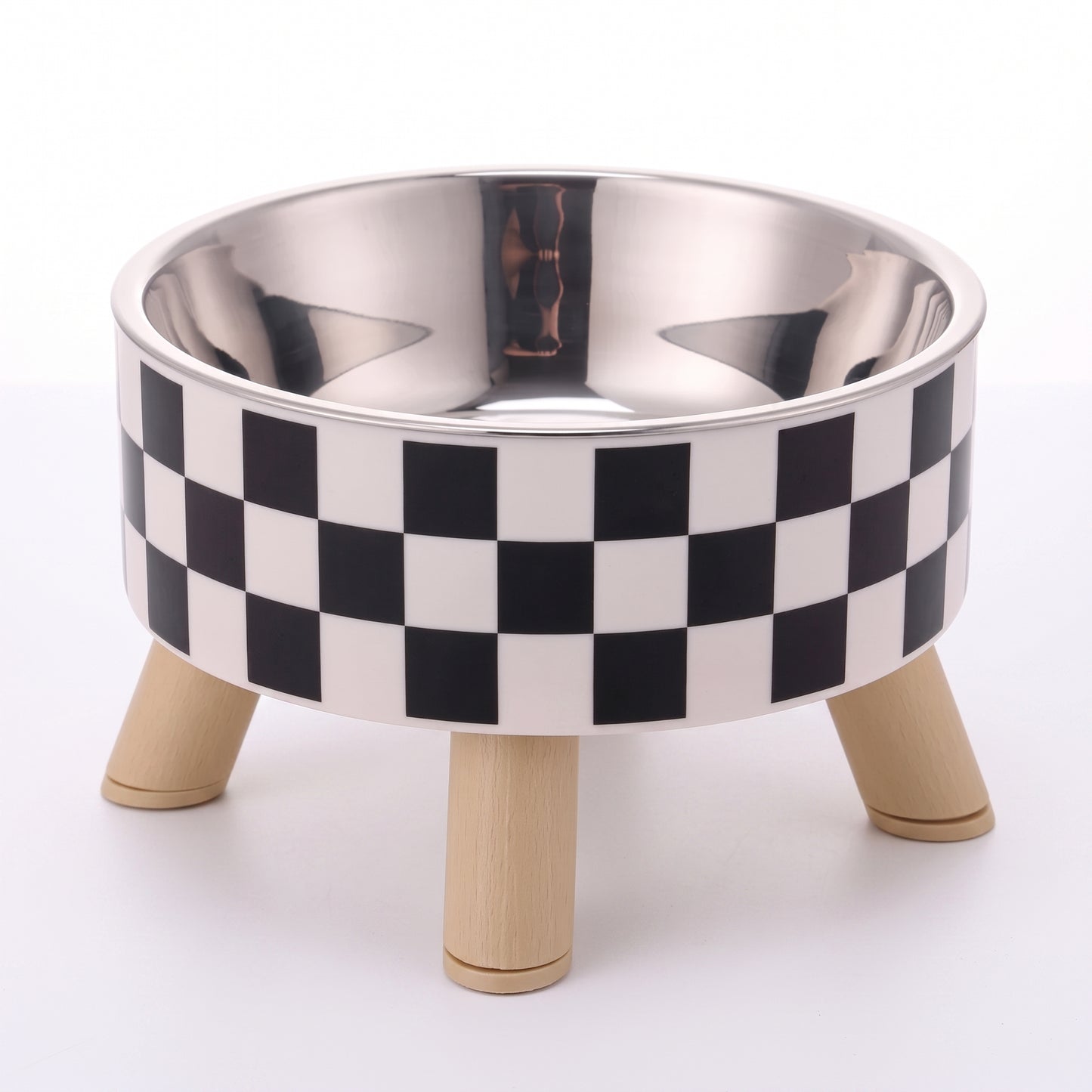 A pet elevated bowl with a black and white checkered pattern on the exterior, a polished stainless steel interior, and three light natural wood legs, shown on a white background.