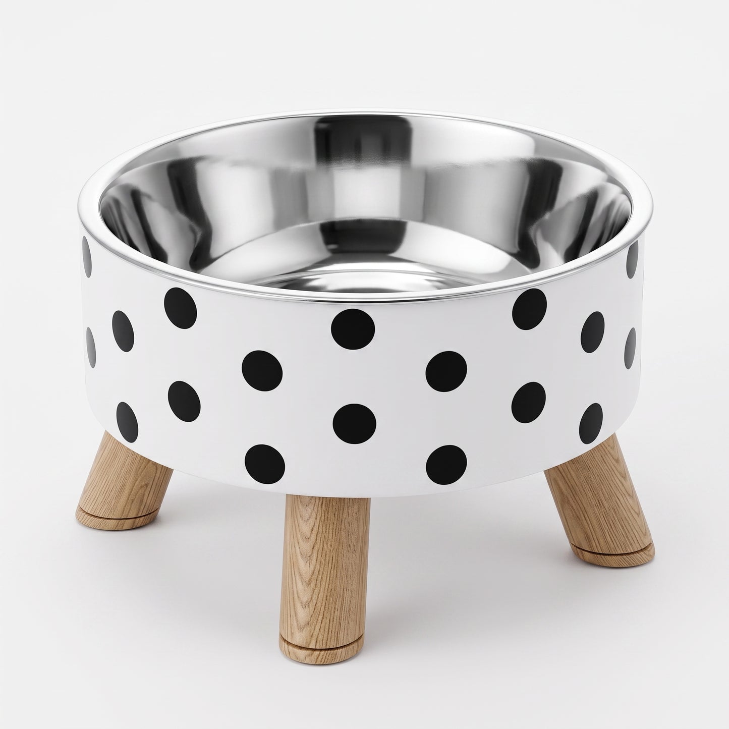 A high-rise pet bowl with a white exterior decorated with black polka dots, a polished stainless steel interior, and three light natural wood legs, shown on a clean white background.